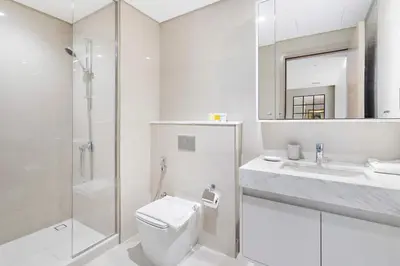 a bathroom with a toilet and a sink and a shower at Silkhaus in Burj Royale, stunning 1BR in Downtown premium tower in Dubai