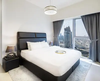 a bedroom with a large bed with a large window at Nasma Luxury Stays - Central Park Tower in Dubai