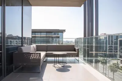 a living room with a couch and a table on a balcony at Nasma Luxury Stays - City Walk Building 5 in Dubai