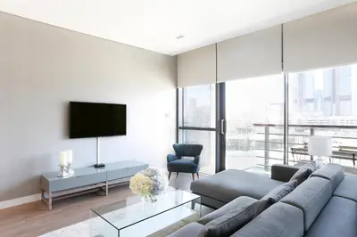 a living room with a couch and a tv at Nasma Luxury Stays - City Walk Building 5 in Dubai