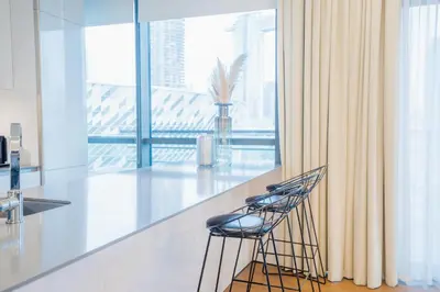 a kitchen with a counter and two stools at Nasma Luxury Stays - City Walk Building 5 in Dubai