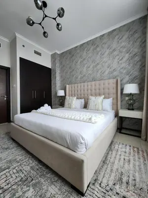 a large white bed in a bedroom with a wall at Nasma Luxury Stays - Marina-View Oasis With Balcony Steps From The Sea in Dubai