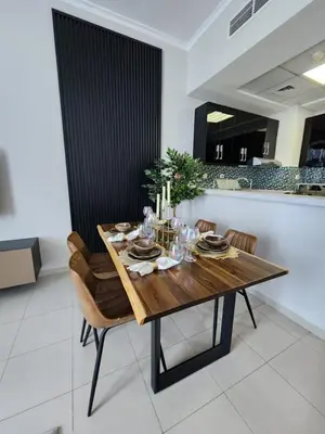 a dining room with a wooden table and chairs at Nasma Luxury Stays - Marina-View Oasis With Balcony Steps From The Sea in Dubai