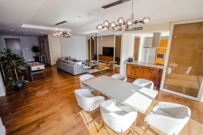 a dining room and living room with a table and chairs at Nasma Luxury Stays - Limestone House in Dubai
