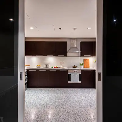 a kitchen with brown cabinets and a stove top oven at Nasma Luxury Stays - Limestone House in Dubai
