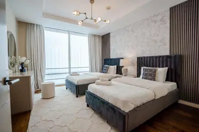 a bedroom with two beds and a large window at Nasma Luxury Stays - Limestone House in Dubai