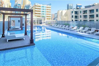 a large swimming pool with lounge chairs on a building at Cosy & Chic Studio One Marina with balcony & View in Dubai