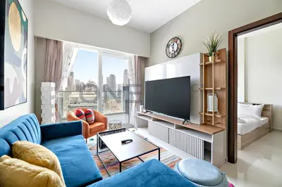 a living room with a blue couch and a tv at In the heart of Business Bay - Bills included in Dubai