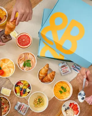 a table topped with bowls of food and a sign at Cosmos Living Dubai Arch Tower Pool, Gym & Balcony in Dubai