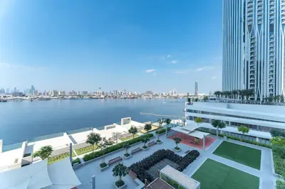 an aerial view of a building next to a body of water at Vogue Creek Harbour The Grand Waterfront Living close to Downtown, Burj Khalifa and Dubai Mall, Two Bedroom Apartment with Balcony, Canal and Vibrant Community View, Access to all Amenities in Dubai
