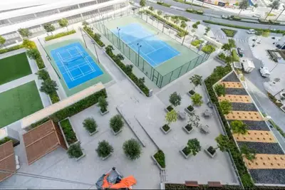 an overhead view of a tennis court with two courts at Vogue Creek Harbour The Grand Waterfront Living close to Downtown, Burj Khalifa and Dubai Mall, Two Bedroom Apartment with Balcony, Canal and Vibrant Community View, Access to all Amenities in Dubai