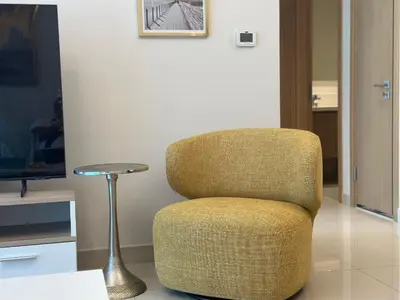 a chair in a living room with a television at ROYAL APARTMENTS DUBAI in Dubai