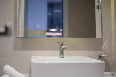 a white sink in a bathroom with a mirror at ALiving Stylish Studio with Partial Burj & Canal Views- Prive , Business bay 713 in Dubai