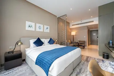 a bedroom with a large bed and a living room at ALiving Stylish Studio with Partial Burj & Canal Views- Prive , Business bay 713 in Dubai