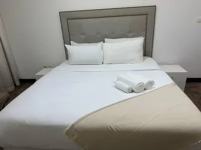 a large white bed with two rolled towels on it at ModernLux - Luxury Duplex 1 BR in Movenpick Hotel JLT with Lake View in Dubai