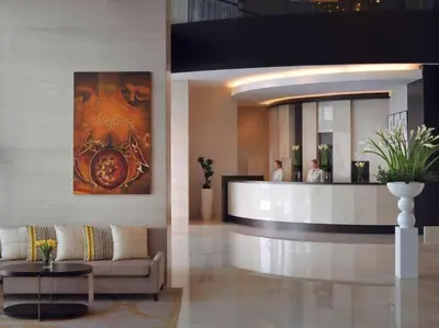 a lobby with a couch and a bar in a building at ModernLux - Luxury Duplex 1 BR in Movenpick Hotel JLT with Lake View in Dubai