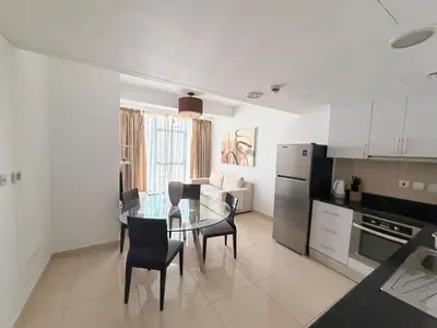 a kitchen and dining room with a glass table and chairs at ModernLux - Luxury Duplex 1 BR in Movenpick Hotel JLT with Lake View in Dubai