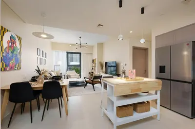 a kitchen and living room with a table and chairs at Maison Privee - Luxury 2Bedroom with Burj Khalifa & Fountain Views in Dubai