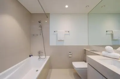 a bathroom with a tub and a toilet and a sink at Maison Privee - Luxury 2Bedroom with Burj Khalifa & Fountain Views in Dubai