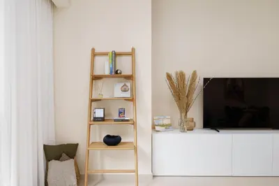 a living room with a book shelf and a tv at Maison Privee - Luxury 2Bedroom with Burj Khalifa & Fountain Views in Dubai