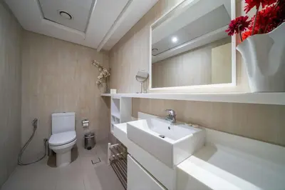 a bathroom with a sink and a toilet and a mirror at Beachfront 1 Bed with Full JBR View in Dubai