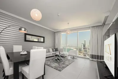 a living room with a table and a dining room at Beachfront 1 Bed with Full JBR View in Dubai