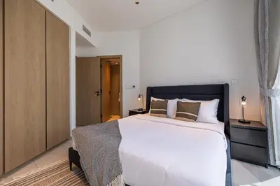 a bedroom with a large white bed and a closet at 3BDR Apartment with Maid Room and Burj Khalifa View in Dubai