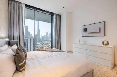 a bedroom with a white bed and a large window at 3BDR Apartment with Maid Room and Burj Khalifa View in Dubai