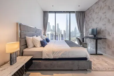 a bedroom with a large bed and a large window at 3BDR Apartment with Maid Room and Burj Khalifa View in Dubai
