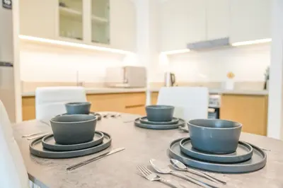 three cups on a table in a kitchen at Elegant Apartment With Balcony Amidst Vibrant Area in Dubai