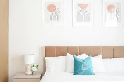 a bedroom with a bed with a blue pillow on it at Elegant Apartment With Balcony Amidst Vibrant Area in Dubai