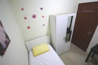 a small bathroom with a yellow stool next to a mirror at Roomy Dubai Hostel Small Rooms and Partitions at Marina in Dubai