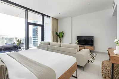 a bedroom with a bed and a couch and a tv at Frank Porter - Marquise Square Tower in Dubai