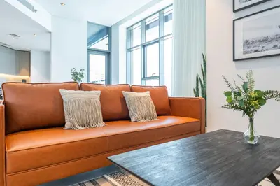 an orange couch in a living room with a table at Contemporary Ranch Living with Burj Khalifa View in Dubai