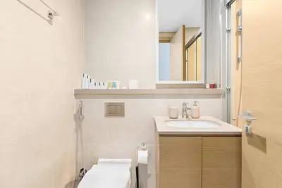 a white bathroom with a sink and a mirror at Modern 1bdr - 10min from Burj Khalifa - Sobha Waves in Dubai
