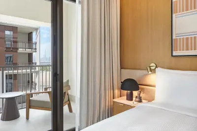a bedroom with a bed and a balcony at Vida Creek Beach Hotel in Dubai