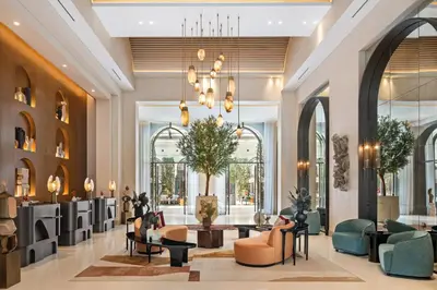 a lobby with couches and chairs and a chandelier at Vida Creek Beach Hotel in Dubai