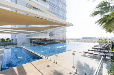 a swimming pool on the side of a building at Opulent Studio at Carson C DAMAC Hills Dubailand by Deluxe Holiday Homes in Dubai
