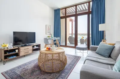 a living room with a couch and a tv at Frank Porter - Palm Views East in Dubai