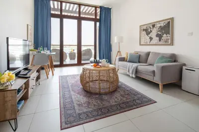 a living room with a couch and a tv at Frank Porter - Palm Views East in Dubai
