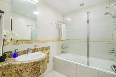 a bathroom with a sink and a tub and a shower at The Smart Concierge - Princess tower in Dubai