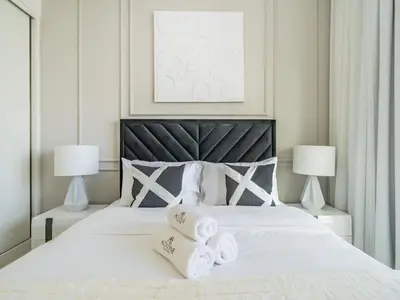a bedroom with a white bed with towels on it at Exceptional 2BR-Private Beach Access-Palm Jumeirah in Dubai