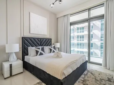 a bedroom with a large bed and a large window at Exceptional 2BR-Private Beach Access-Palm Jumeirah in Dubai