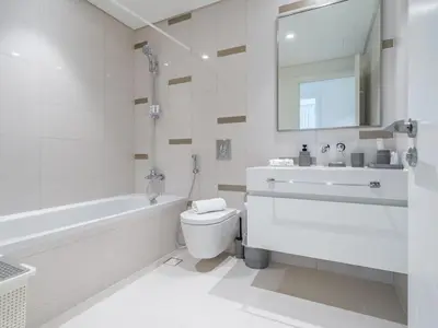 a white bathroom with a sink and a toilet at Exceptional 2BR-Private Beach Access-Palm Jumeirah in Dubai