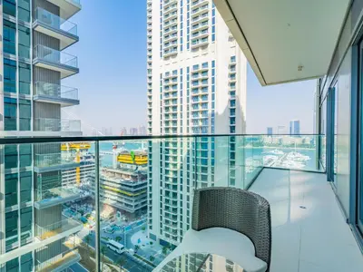 a chair on a balcony with a view of a city at Exceptional 2BR-Private Beach Access-Palm Jumeirah in Dubai