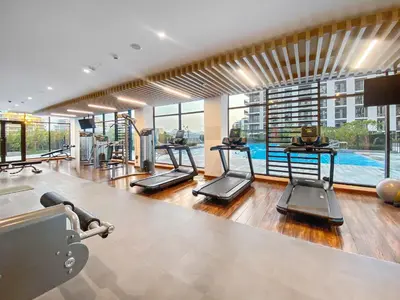 an indoor gym with treadmills and a swimming pool at Silkhaus new 1BDR in Executive Residence 2 in Dubai