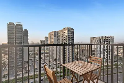 a table and chairs on a balcony with buildings at Silkhaus new 1BDR in Executive Residence 2 in Dubai