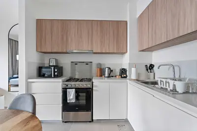 a kitchen with white cabinets and a stove top oven at Silkhaus new 1BDR in Executive Residence 2 in Dubai
