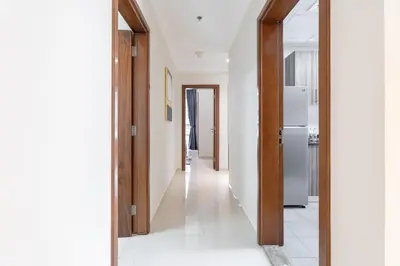 a hallway of a house with white walls and a refrigerator at Dunya Tower Luxury and 2 min walk to Dubai Mall and Burj Khalifa in heart of Downtown in Dubai