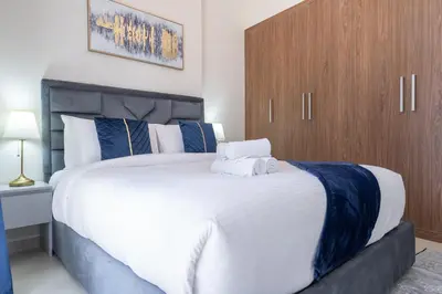 a bedroom with a large white bed with blue pillows at Dunya Tower Luxury and 2 min walk to Dubai Mall and Burj Khalifa in heart of Downtown in Dubai